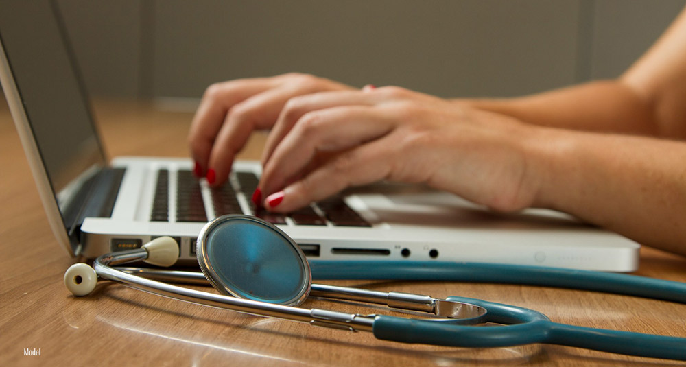 A person performing research on their laptop while preparing for cosmetic surgery.