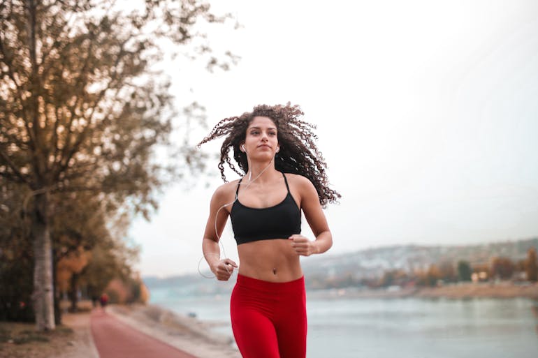 a woman jogging by the water