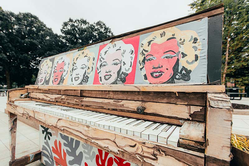 A piano with Marilyn Monroe pictures.