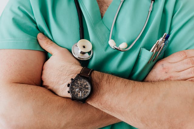 Caption: Communication with your surgeon and regular consultations play a key role in achieving your desired surgery results. Alt text: Doctor with a stethoscope, a pen in his pocket, and a black watch.